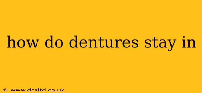 how do dentures stay in